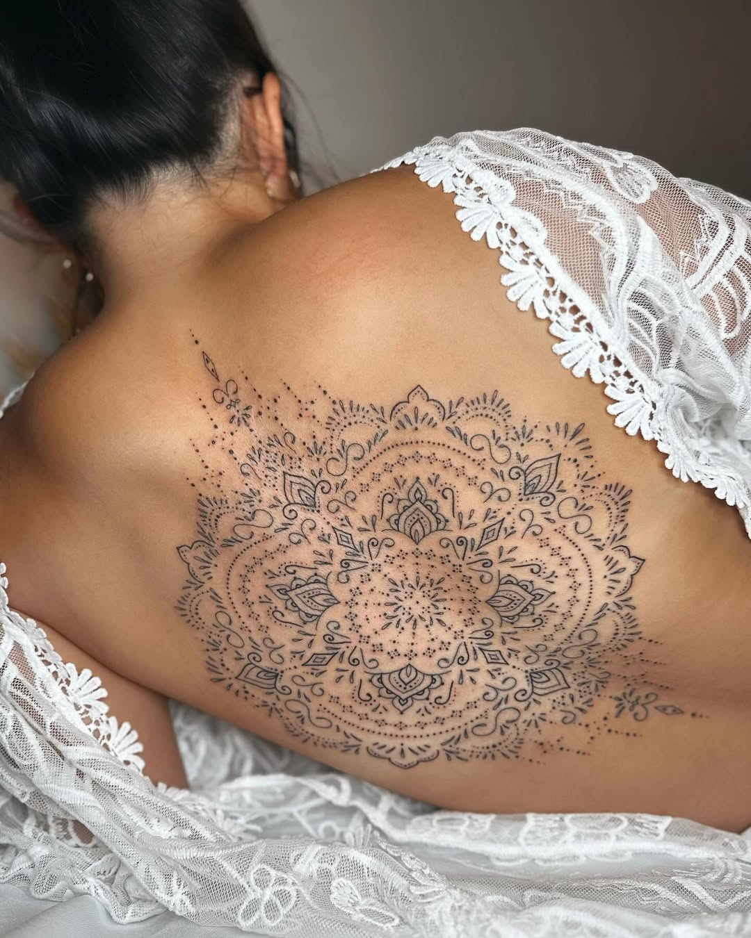 Frau trägt Mandala Tattoo am Rücken